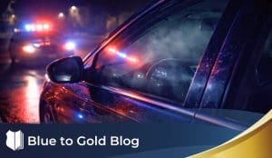 Nighttime traffic stop with police lights reflecting on a sedan and faint haze visible inside the driver’s window.